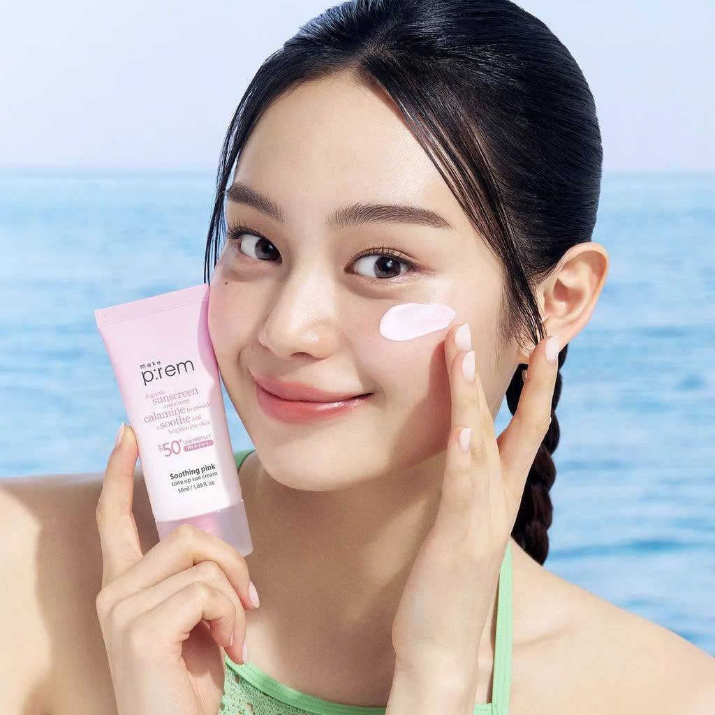 MAKE P:REM  Soothing Pink Tone-Up Sunscreen SPF 50+ PA++++ 50ml, femme à la plage, crème solaire rose sur le visage.