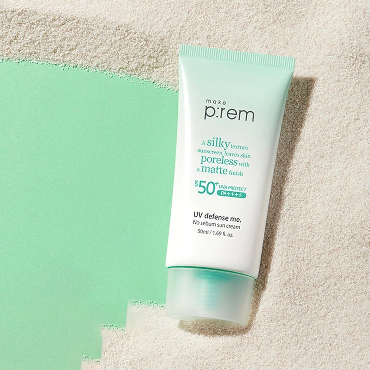 MAKE P:REM UV Defense Me No-Sebum Sunscreen 50ml : tube crème anti-brillance sur fond sable, style été.