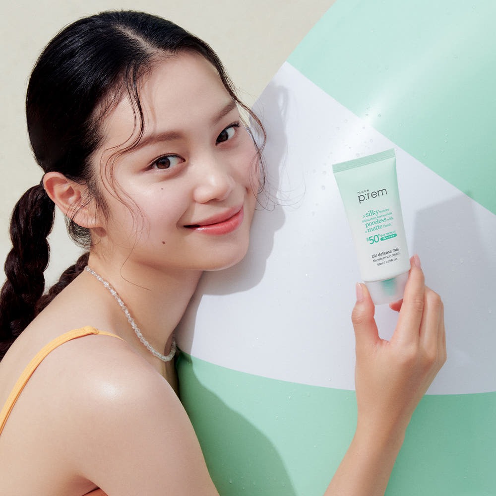 MAKE P:REM UV Defense Me No-Sebum Sunscreen 50ml, produit de la marque sur une femme au soleil, étiquette visible.