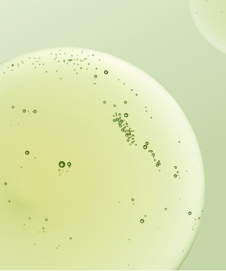 Texture du sérum MAKE P:REM Endpore Vegetinol Tightening Serum 50ml en gros plan avec bulles sur fond vert clair.