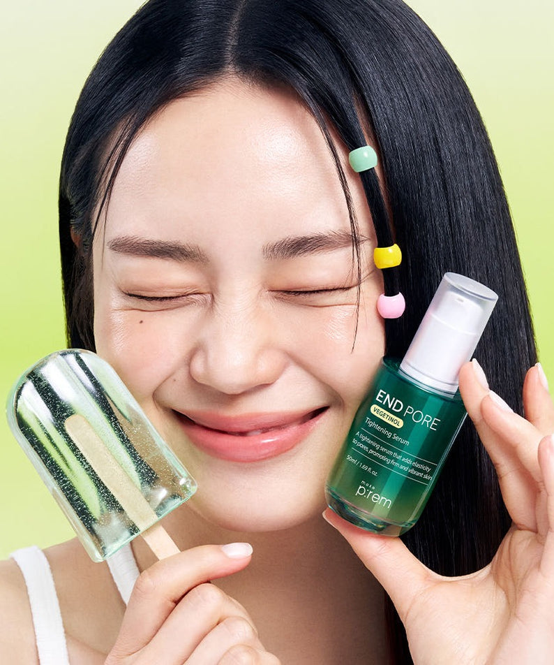 Femme souriante tenant MAKE P:REM Endpore Vegetinol Tightening Serum 50ml avec glaces en arrière-plan.