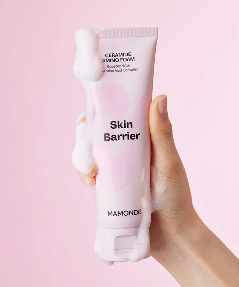 MAMONDE Ceramide Amino Foam 120g mousse nettoyante pour le visage, main tenant le produit, fond rose.