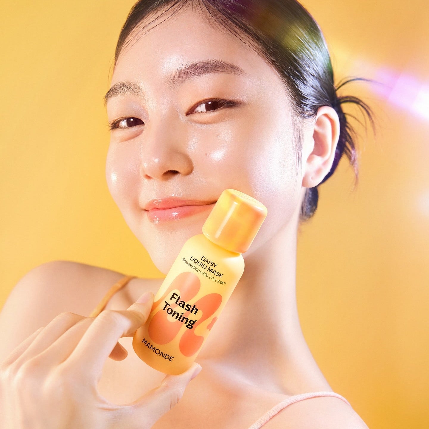 MAMONDE Flash Toning Daisy Liquid Mask 80ml, fille applique un masque liquide en flacon sur fond jaune chaud