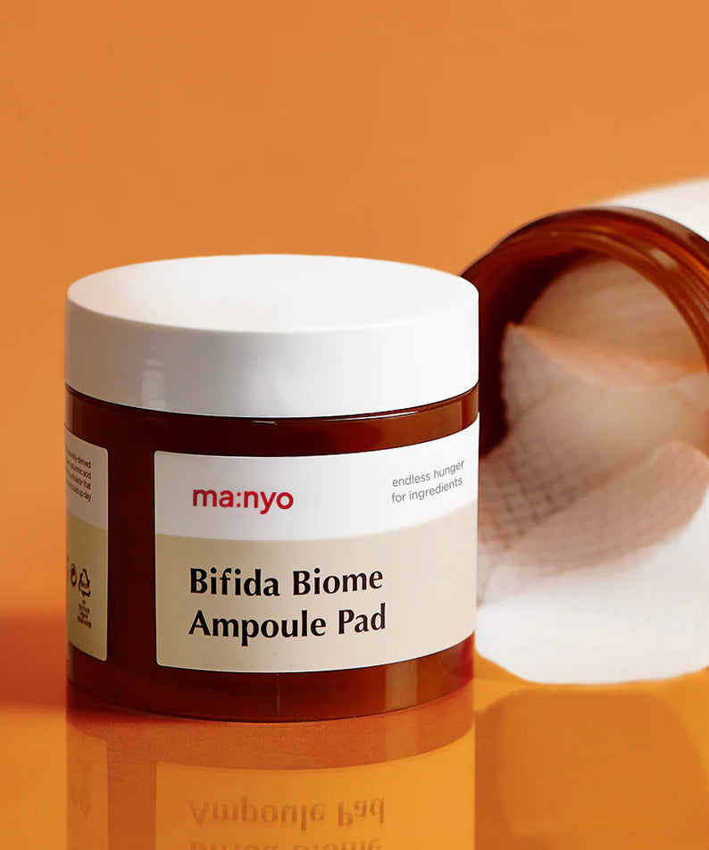 MA:NYO Bifida Biome Ampoule Pad 70 Sheets de la marque MA:NYO, photo produit sur fond orange, compresses cosmétiques.