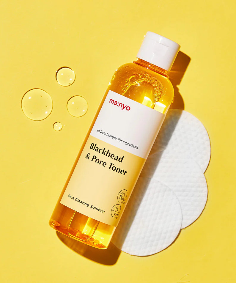 MANYO Blackhead & Pore Toner 210ml sur fond jaune avec des cotons démaquillants. Soin visage pour pores nets et purification de la peau.