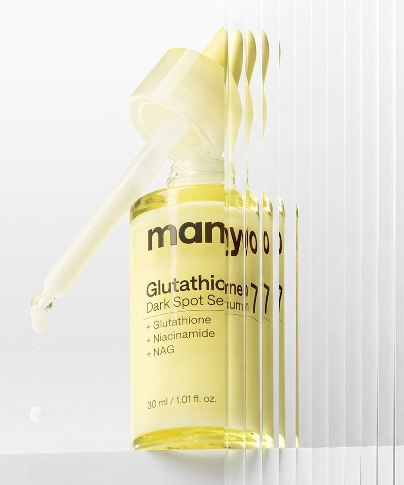 MANYO Glutathione 7 Dark Spot Serum 30ml, sérum anti-taches MANYO en flacon jaune sur fond blanc, goutte à l’avant
