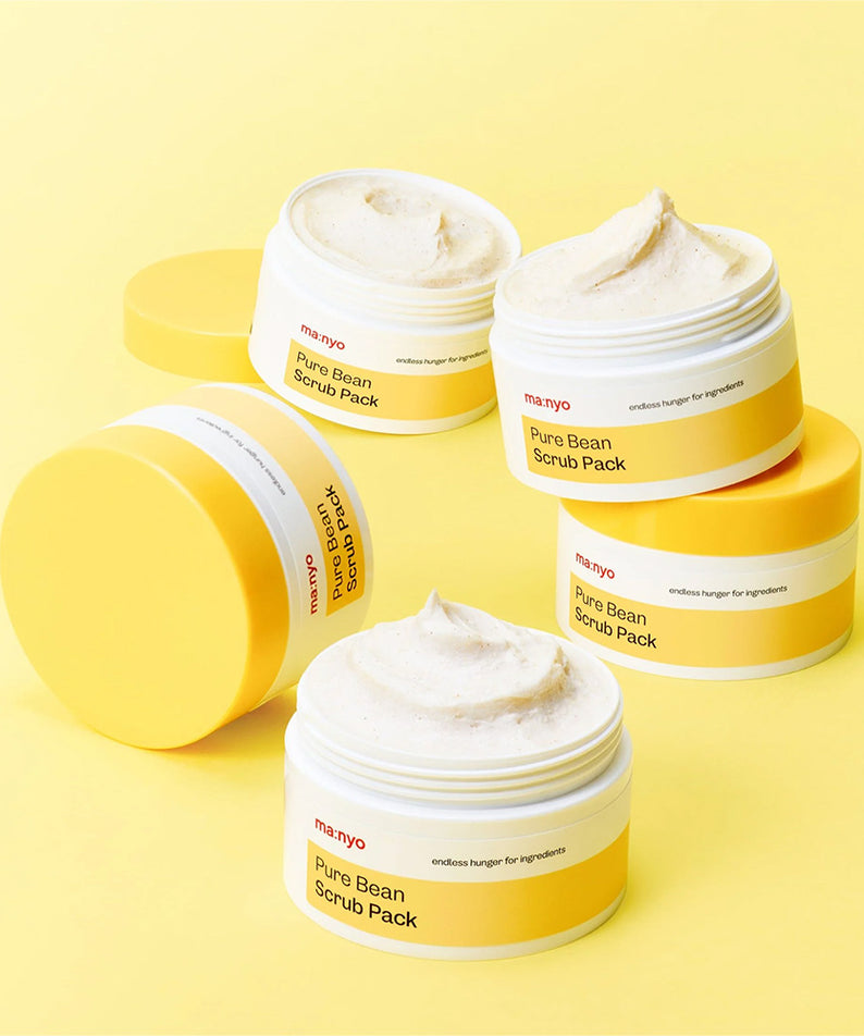 MANYO Pure Bean Scrub Pack 100ml sur fond jaune en pots ouverts, exfoliant visage luxueux pour peau éclatante et douce.