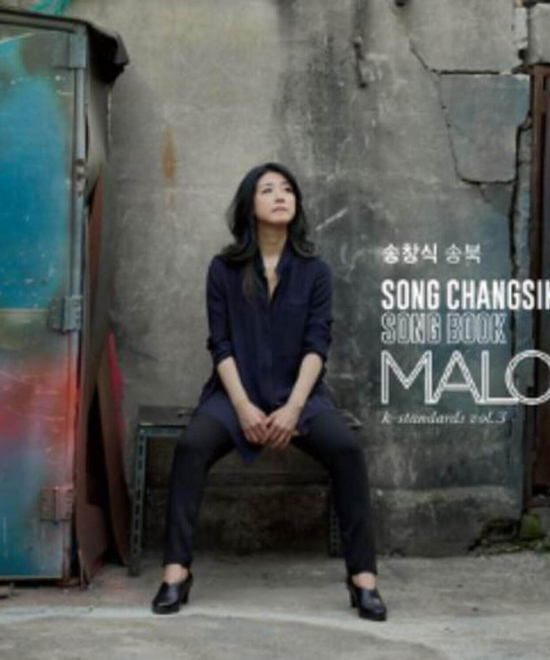 Photo promo MARLO - Album Kpop : la chanteuse MARLO assise devant un mur urbain, ambiance emo, packaging visible