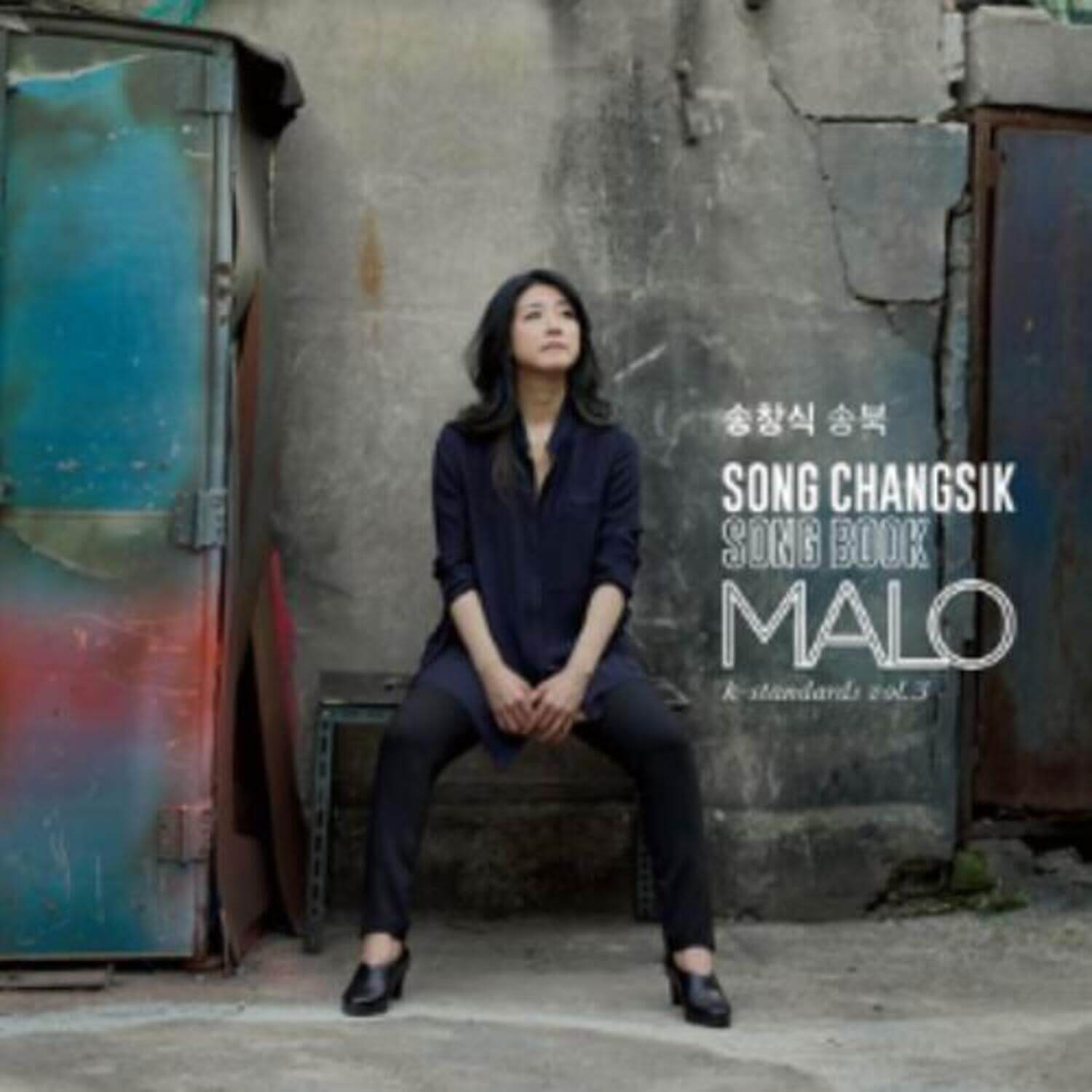 Photo promo MARLO - Album Kpop : la chanteuse MARLO assise devant un mur urbain, ambiance emo, packaging visible