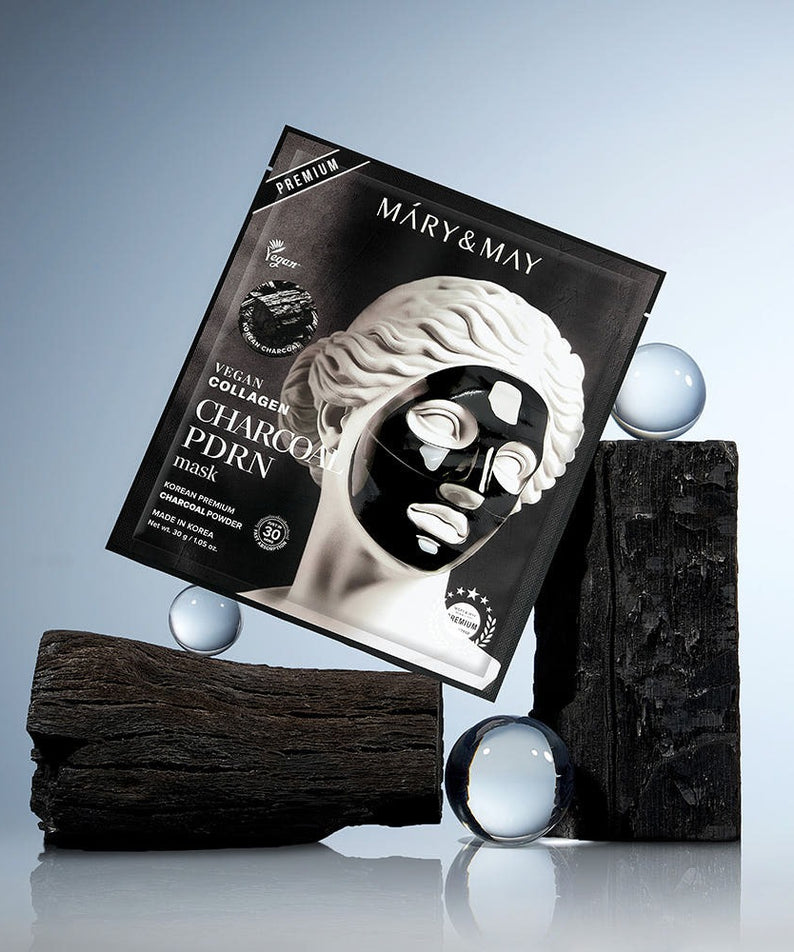 MARY&MAY Vegan Collagen Charcoal PDRN Gel Mask (4 Sheets) en boîte sur fond de bois et verre, produit de soins de la peau.