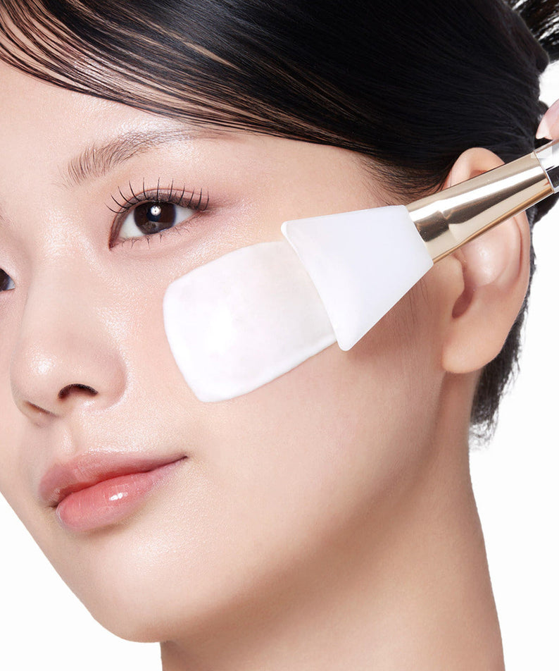 Appliquer MEDICUBE Collagen Milk Wrapping Mask 80ml : une femme avec une spatule, marque et soin visage en gros plan.