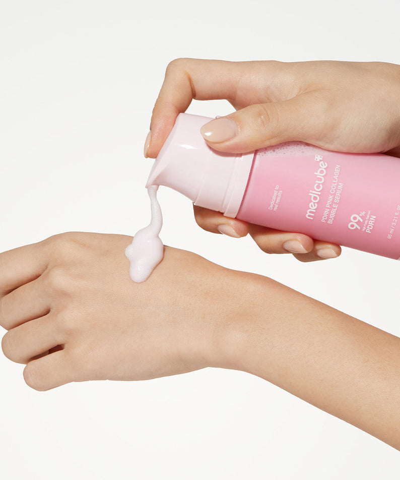 MEDICUBE PDRN Bubble Cream Serum 95ml de la marque MEDICUBE, crème moussante sur la peau, main tenant le flacon rose.