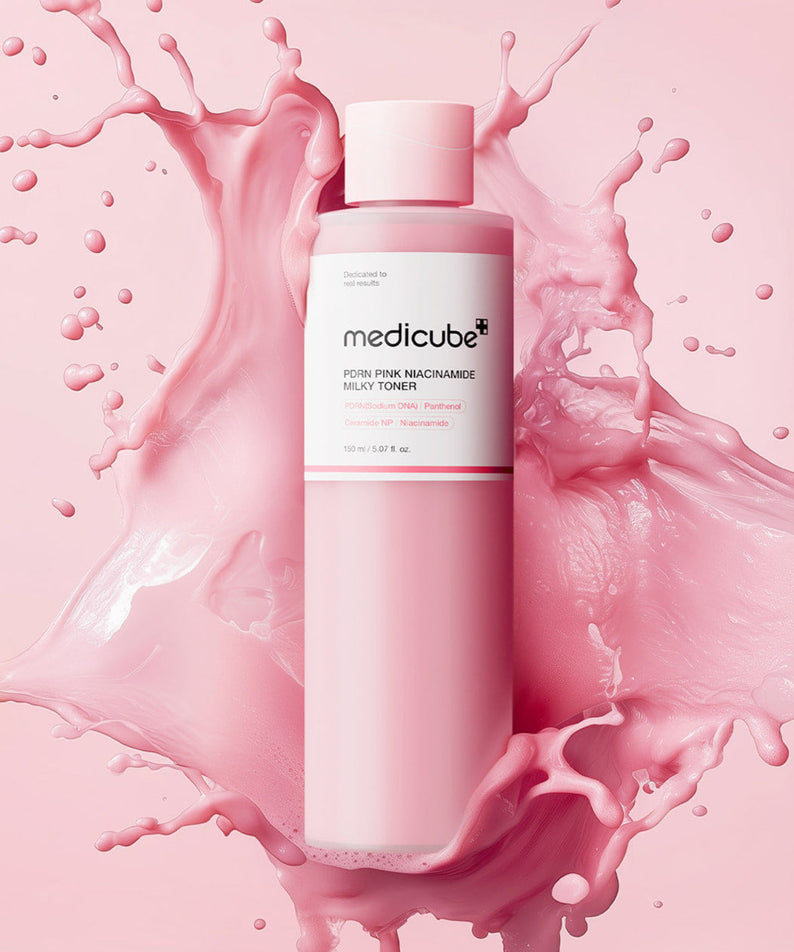 MEDICUBE PDRN Milky Toner Essence 150ml sur fond éclaboussant, soin hydratant et revitalisant en bouteille rose de 150ml.