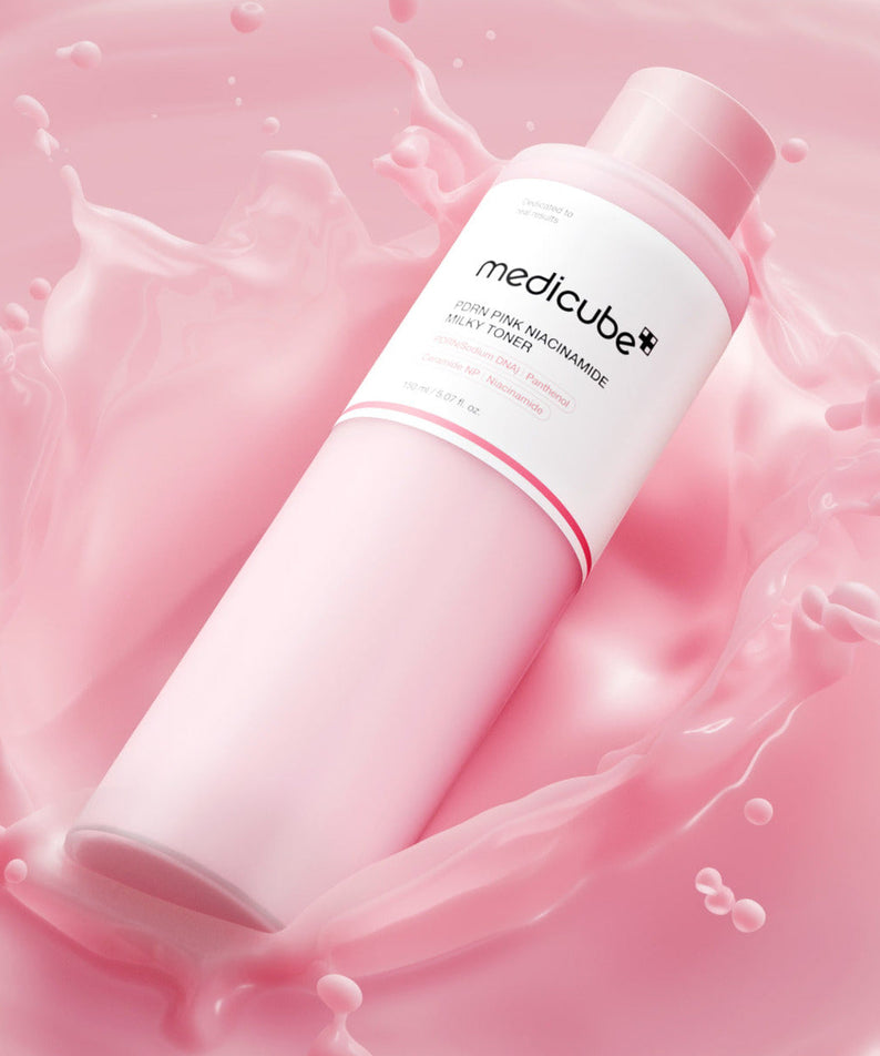 MEDICUBE PDRN Milky Toner Essence 150ml sur fond rose, hydratant et revitalisant, bouteille élégante disposée sur un éclat de lait rose.