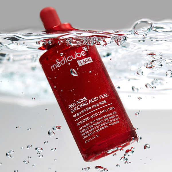 MEDICUBE Red Acne Succinic Acid Peel 40g, flacon rouge sur fond d’eau avec bulles, produit de marque MEDICUBE.