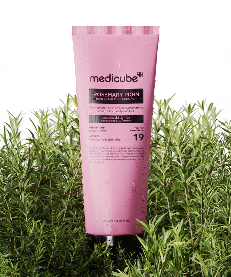 MEDICUBE Rosemary PDRN Hair & Scalp Conditioner 250ml, tube rose de la marque mediciube, posé dans l’herbe verte