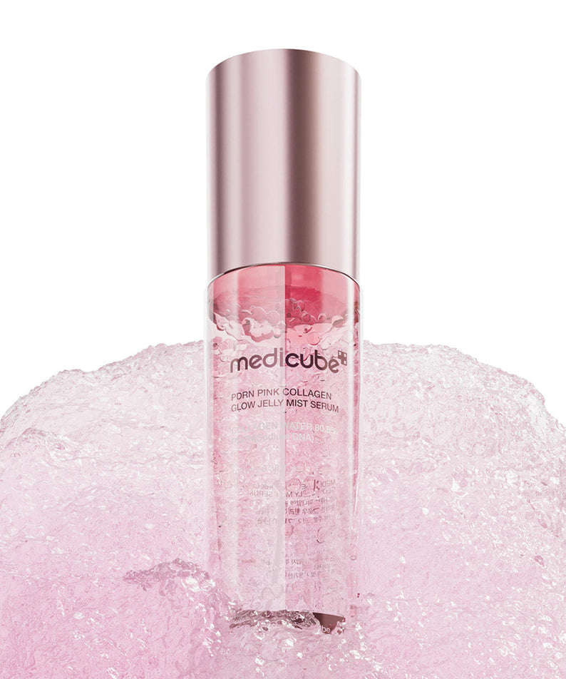 Flacon de MEDICUBE PDRN Pink Collagen Jelly Mist Serum 100ml sur fond rose mousseux.