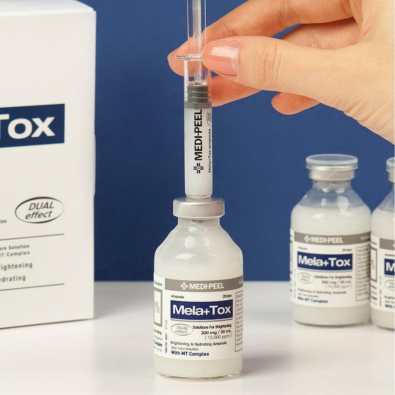 MEDIPEEL Mela Plus Tox Ampoule 35ml : main tient une ampoule, flacons MEDIPEEL sur fond bleu, contexte visuel beauté.