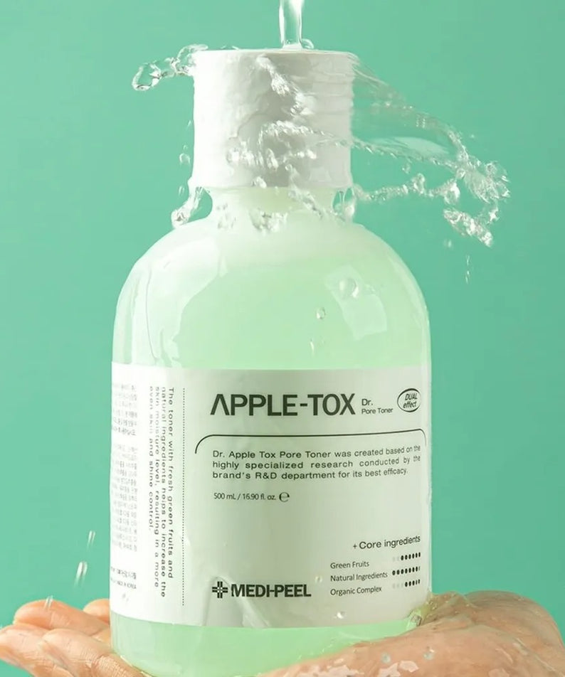 MEDIPEEL Dr.Apple Tox Pore Toner 500ml sur fond vert avec eau qui coule dessus, bouteille montrée sur une main.