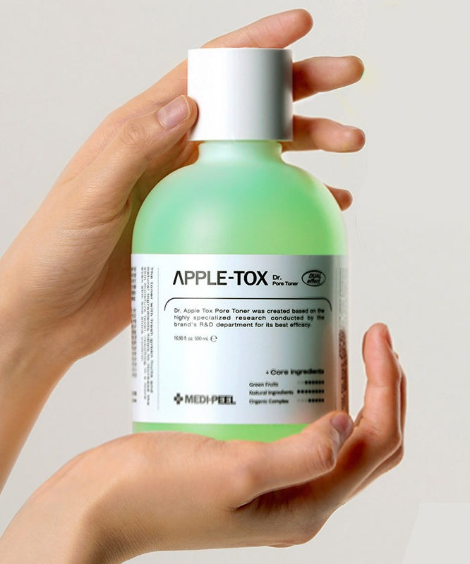 Mains tenant MEDIPEEL Dr.Apple Tox Pore Toner 500ml, flacon vert, soin cosmétique.