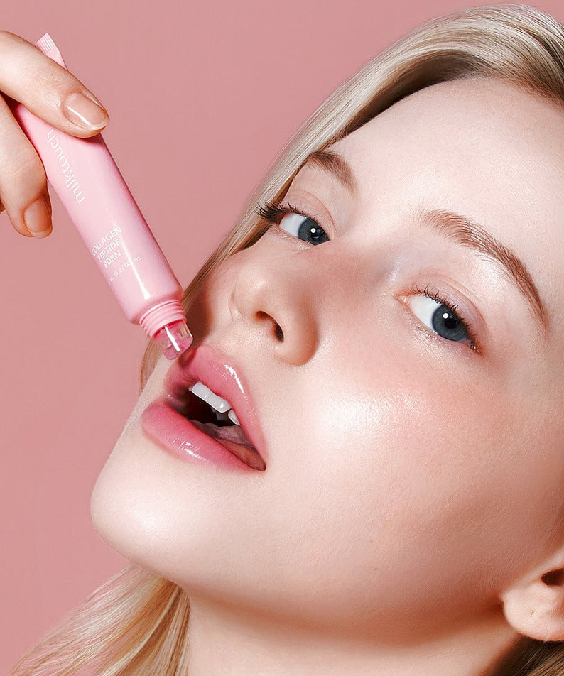 MILK TOUCH Glow Up Collagen Lip Balm 15g sur les lèvres, femme l’applique, packaging rose sur fond rose clair
