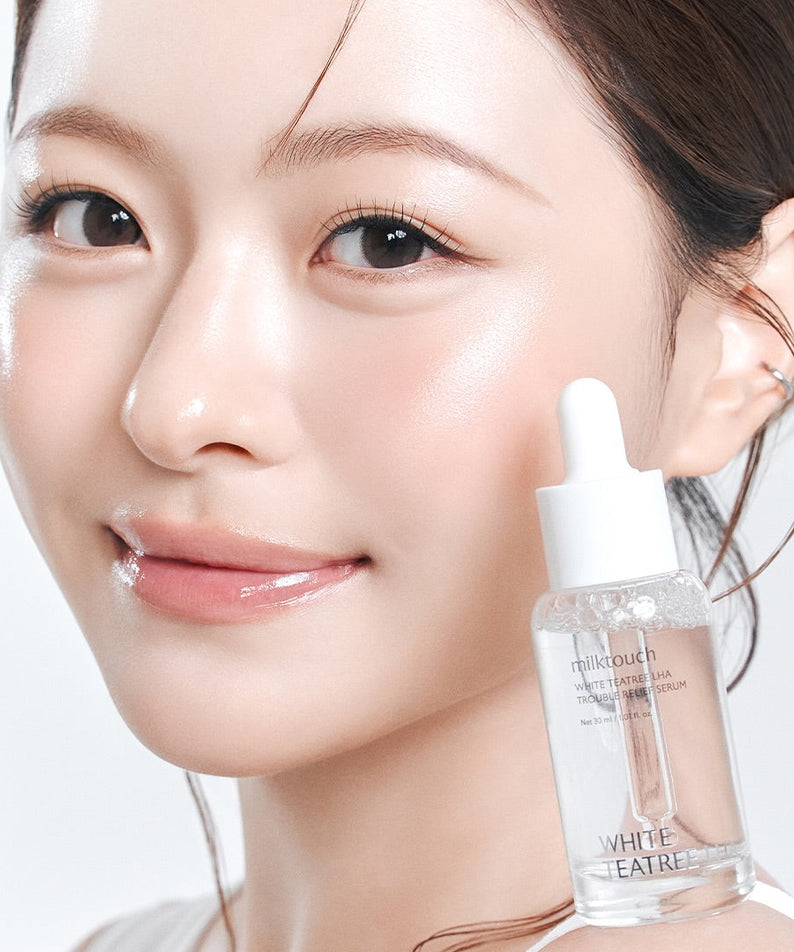 MILK TOUCH White Tea Tree Laha Trouble Relief Serum 30ml, flacon sur fond clair, peau du visage avec application, marque MILK TOUCH.