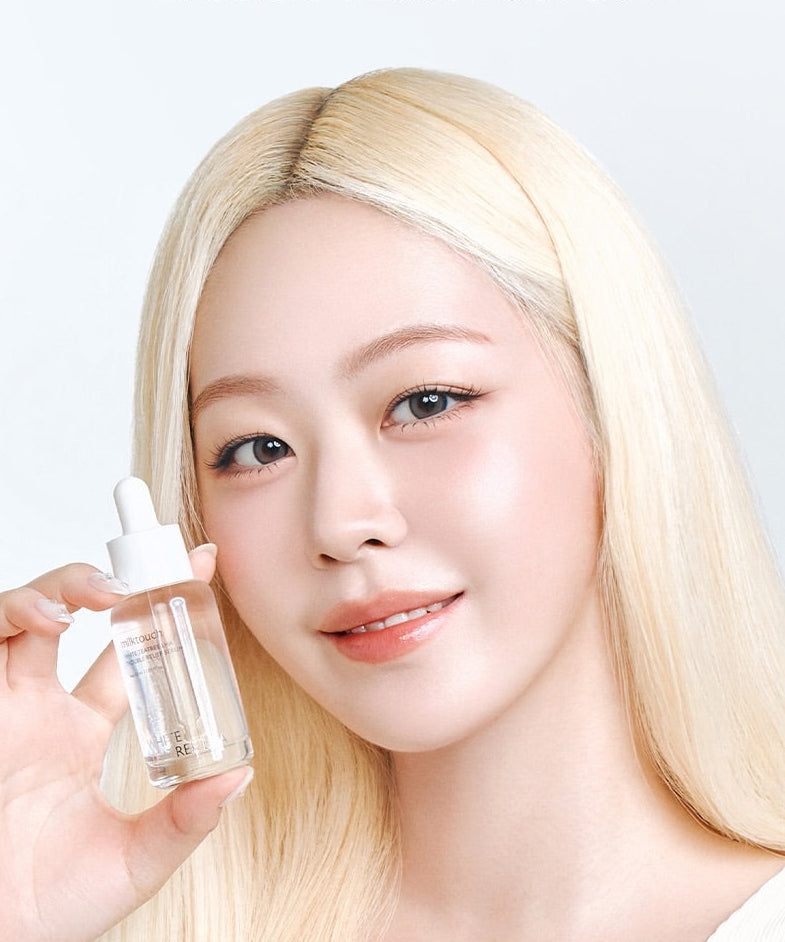 MILK TOUCH White Tea Tree Laha Trouble Relief Serum 30ml, flacon tenu par une femme, fond clair, marque Milk Touch.