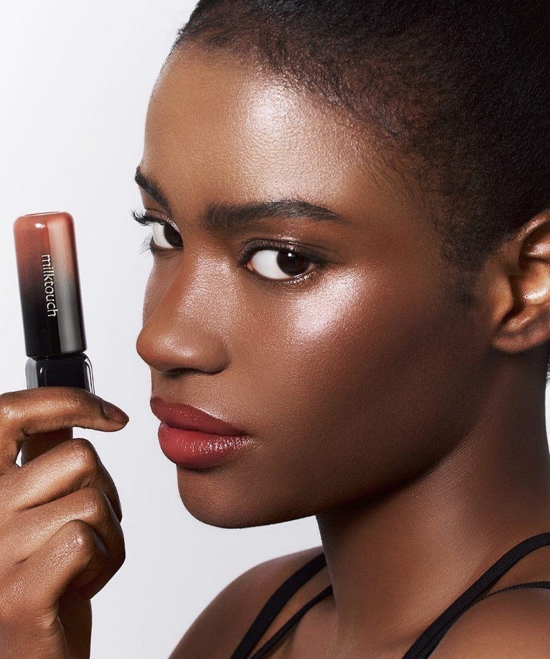 Femme avec MILK TOUCH Black Peel-Off Lip Tattoo, révélant une couleur intense pour des lèvres audacieuses.