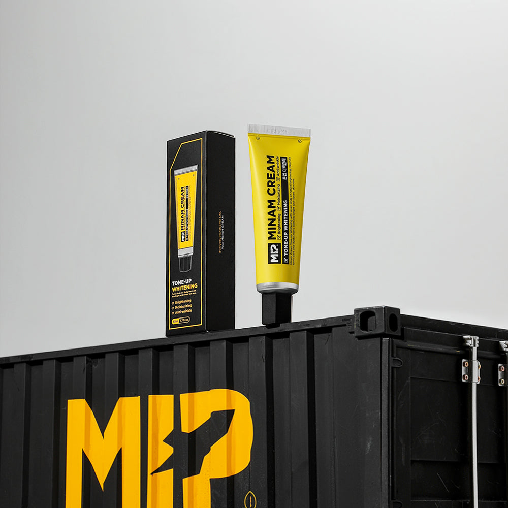 MIP Minam Cream Tone-Up Whitening Cream 50ml de MIP, tube jaune sur présentoir noir, fond clair (produit cosmétique).