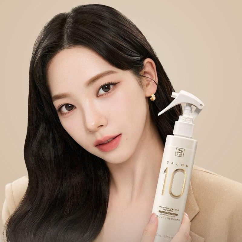 Décris l'image en français : MISE EN SCENE Salon 10 No-Wash Extreme Damage Ampoule Treatment 200ml, flacon tenu par une femme, fond beige.