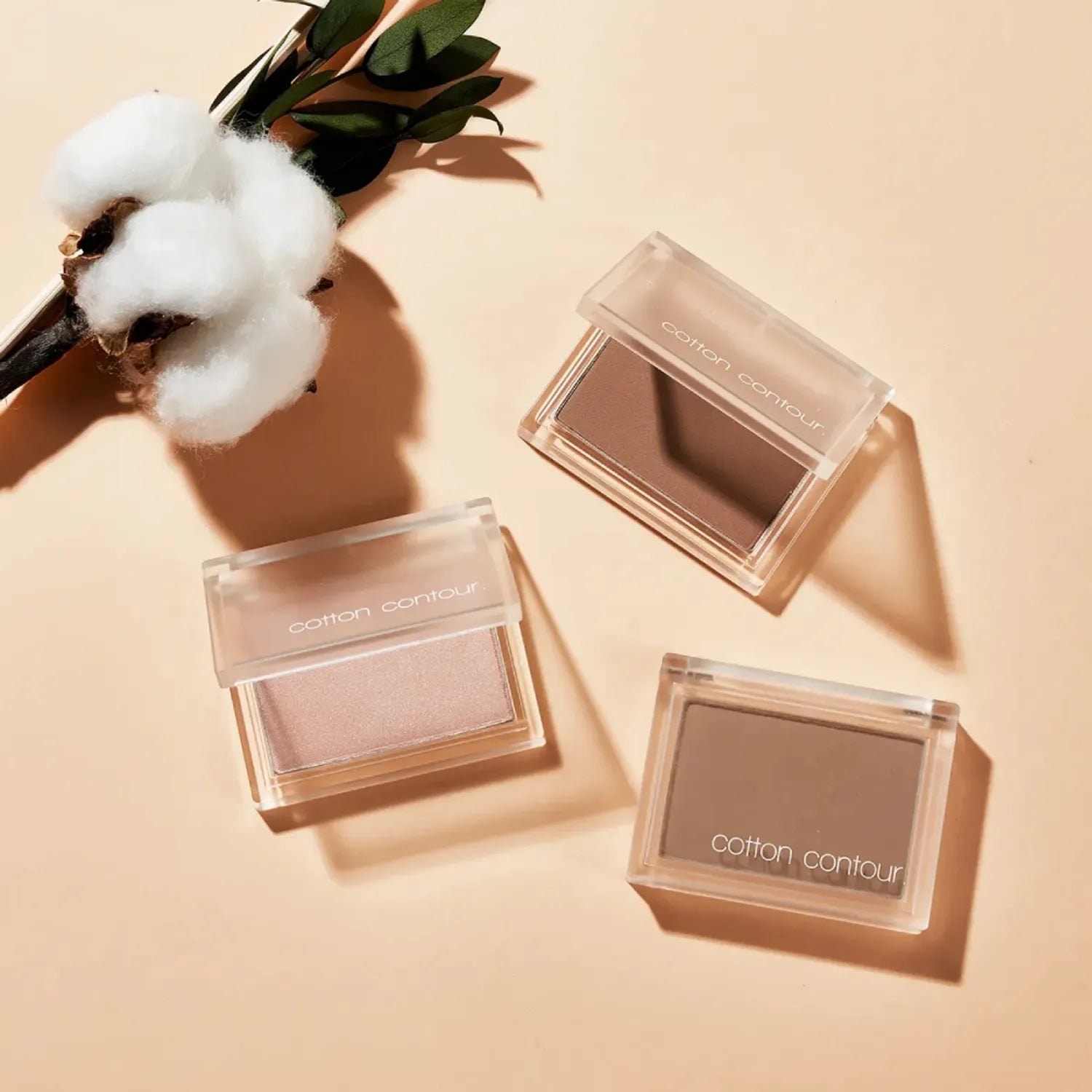 MISSHA  Cotton Contour 4g, poudre contour dans boîtiers transparents sur fond beige avec coton et lumière douce.