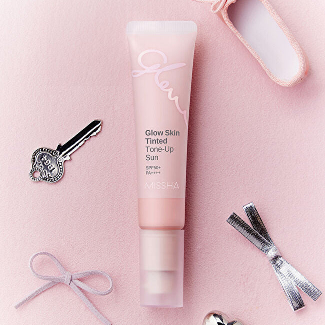 MISSHA  Glow Skin Tinted Tone-Up Sun 30ml, tube rose sur fond pastel avec maquillage, ruban et accessoires