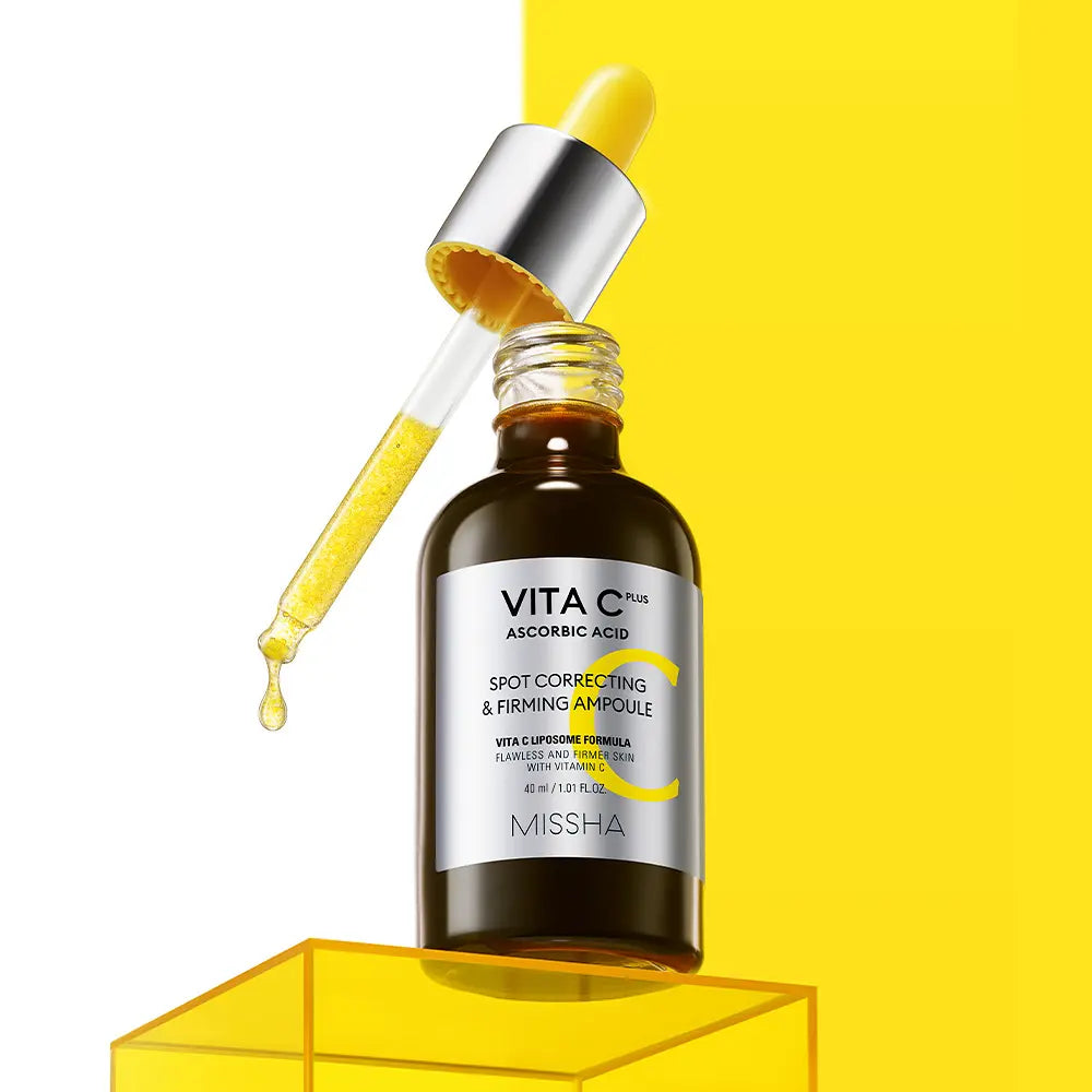 MISSHA  Vita C Plus Blemish C Elasticity Ampoule 40ml : flacon avec goutte d’acide et fond jaune en studio.