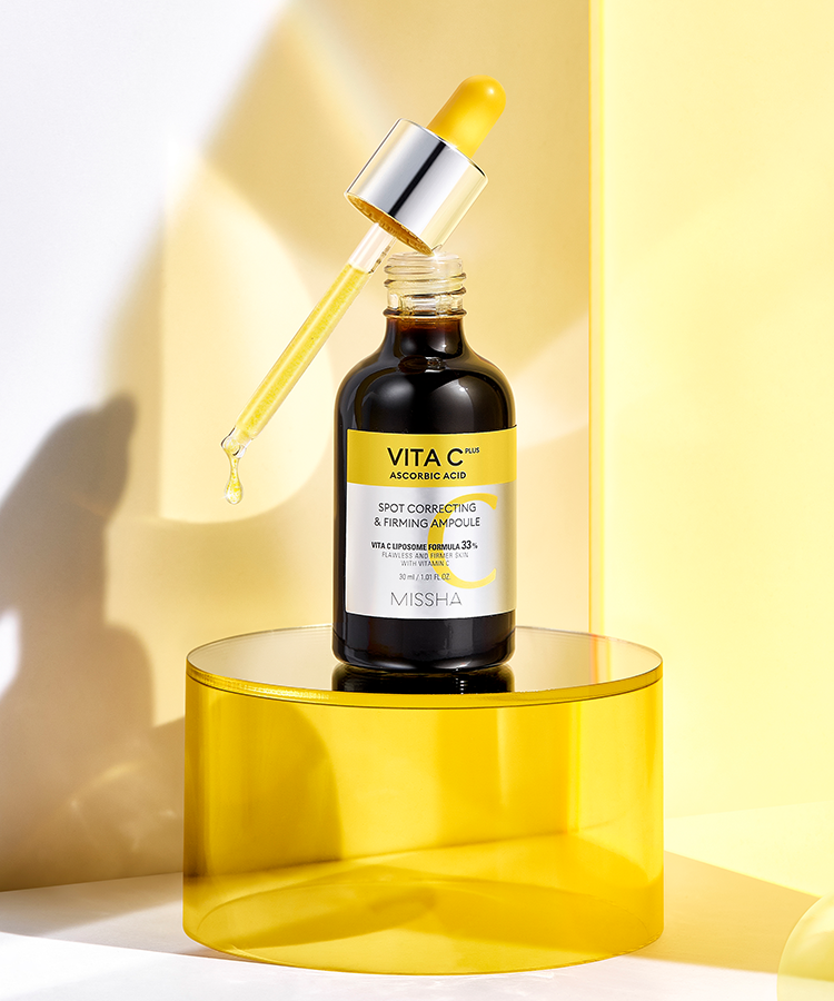 MISSHA  Vita C Plus Blemish C Elasticity Ampoule 40ml, flacon sérum jaune sur podium, ambiance lumineuse en studio
