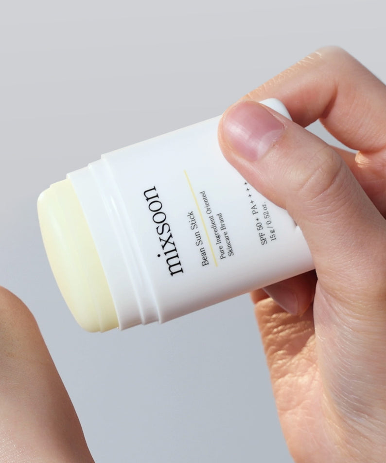 MIXSOON Bean Sun Stick présenté par une main, protection solaire pratique et efficace en bâton.