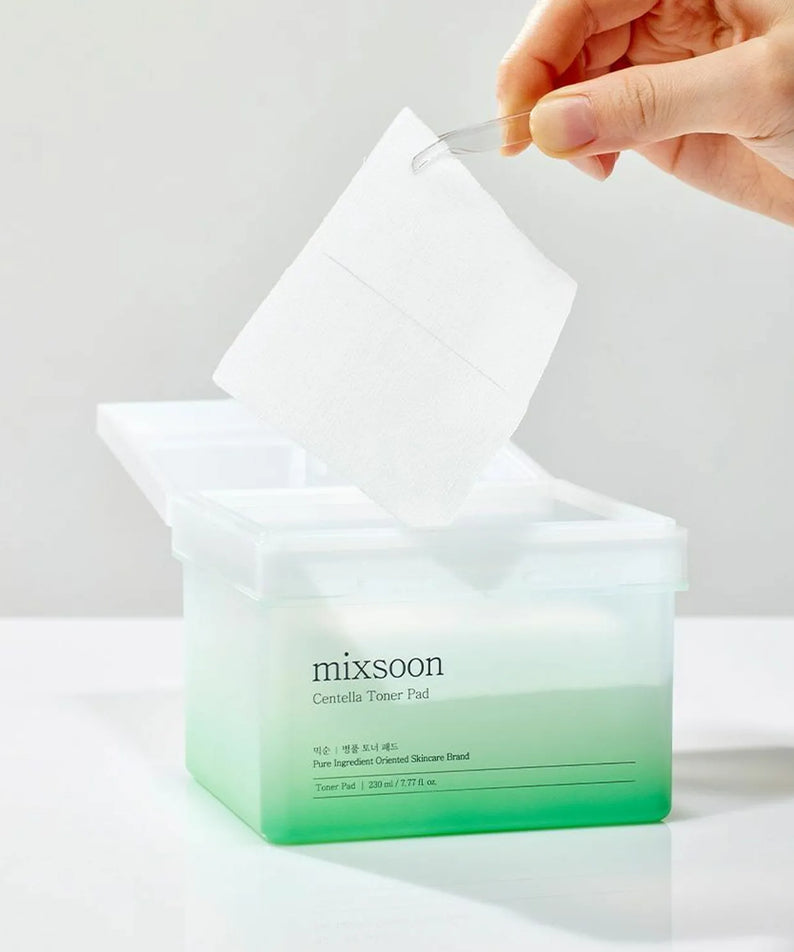 Pad toner MIXSOON Bottle Grass dans un récipient, main retirant un disque. Soin hydratant pour la peau.