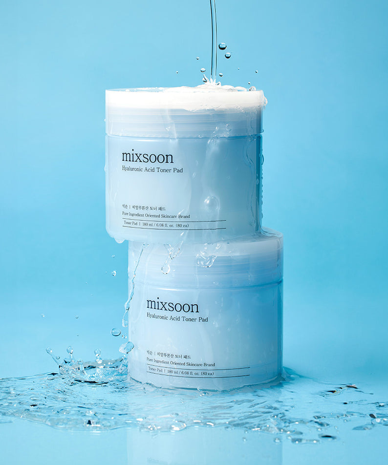 MIXSOON Hyaluronic Acid Toner Pad présenté sur fond bleu avec de l'eau éclaboussant, idéal pour hydrater la peau.