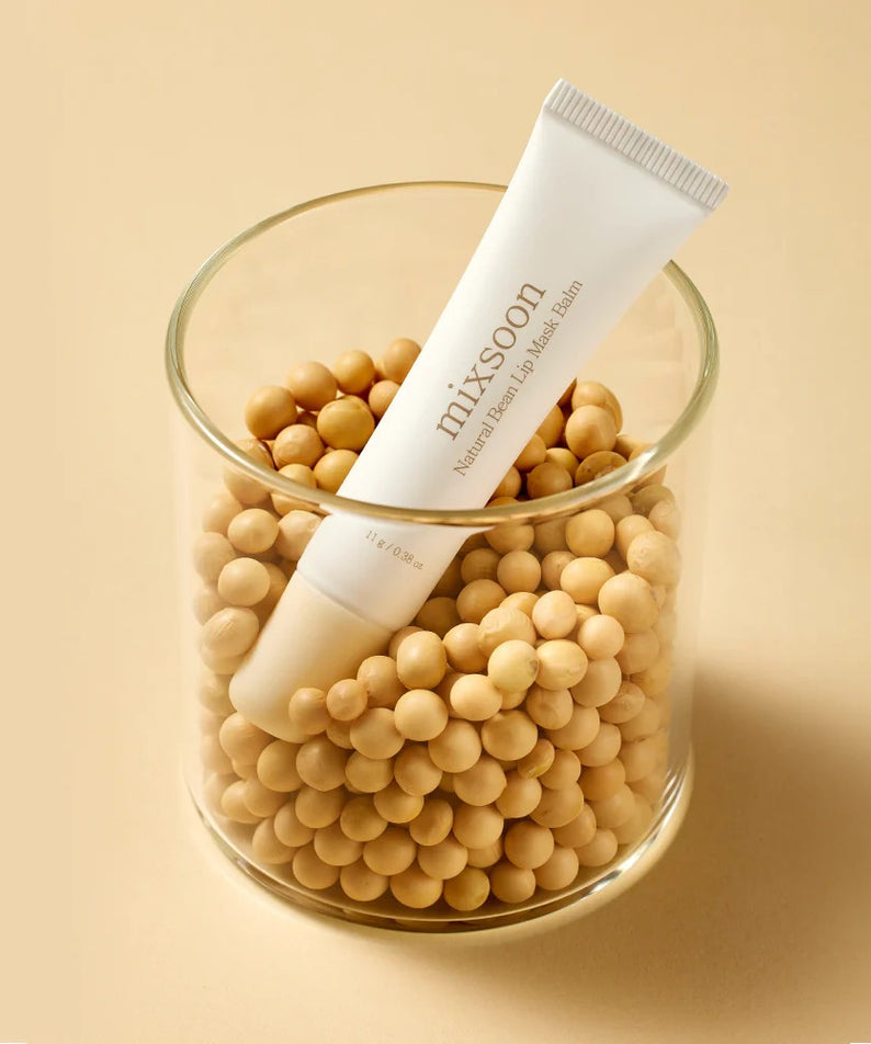 MIXSOON Natural Bean Lip Mask Bean 11g de la marque MIXSOON, posé sur des grains de haricot, fond beige.