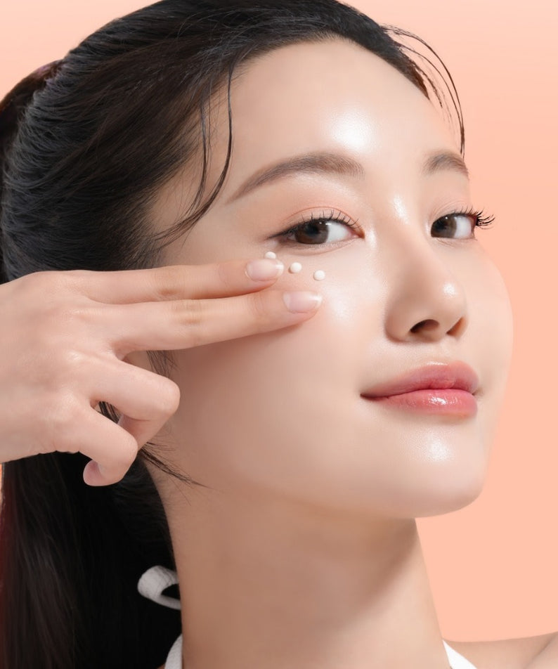 Décris l'image en français : MIXSOON PDRN Collagen Eye Serum 20ml, marque MIXSOON, femme applique au contour des yeux, fond rose.