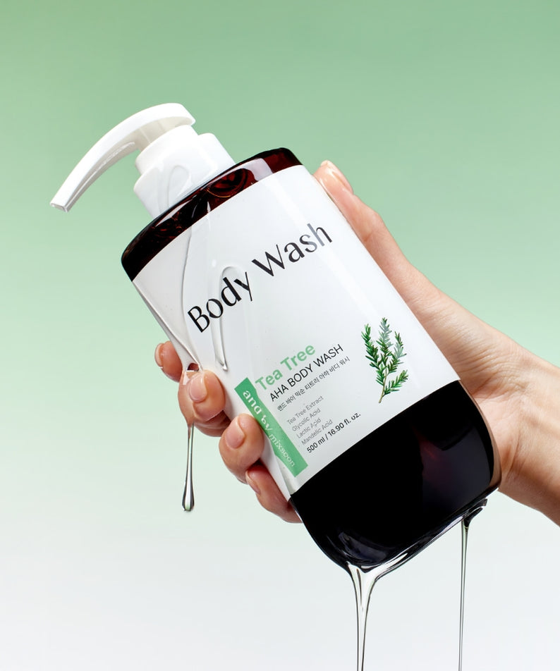 MIXSOON Tea Tree AHA Body Wash 500ml, main tenant le flacon sur fond vert, produit douche illustré.