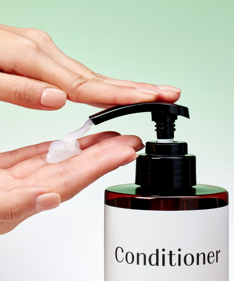 Main appliquant le produit MIXSOON Tea Tree Moisture Conditioner 500ml, marque MIXSOON sur flacon pompe, fond vert pastel.