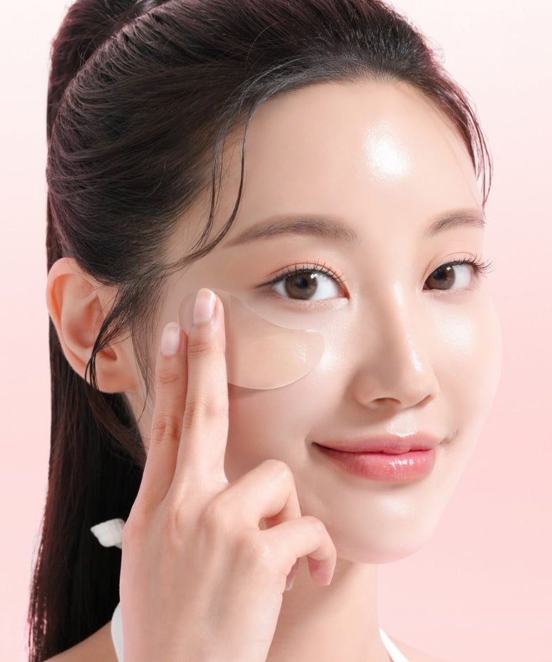 Femme utilisant MIXSOON Collagen Hydrogel Eye Patch Single Pack 5 Sheets sur fond rose.