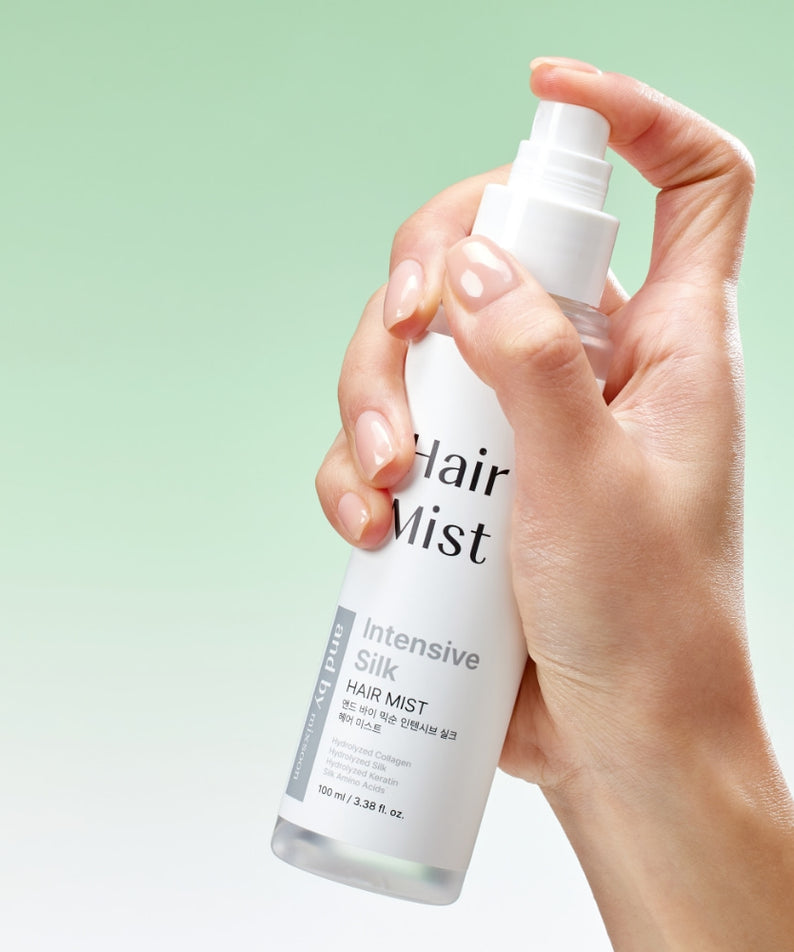 Flacon de MIXSOON Intensive Silk Hair Mist 100ml en main, sur fond vert, pour des cheveux soyeux et revitalisés.