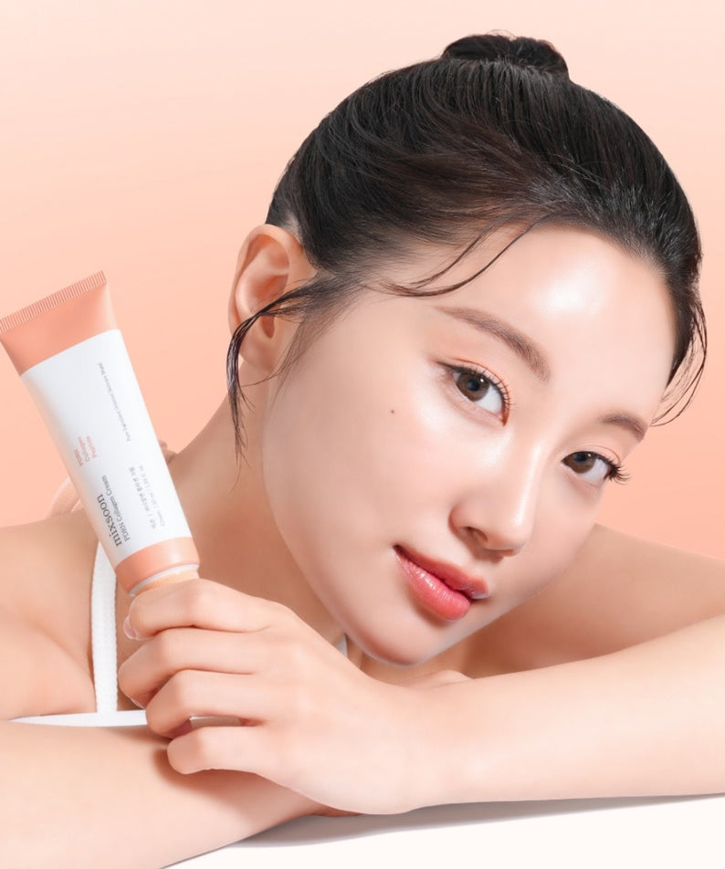 Femme posant avec le tube de MIXSOON PDRN Collagen Cream 50ml sur fond rose pâle.