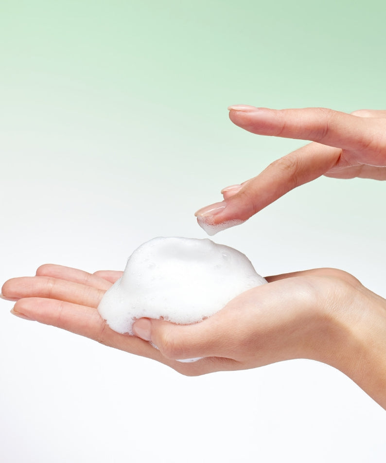 Mousses de lavage corporel MIXSOON Tea Tree AHA Body Wash 500ml dans les mains, idéal pour une peau douce et purifiée.