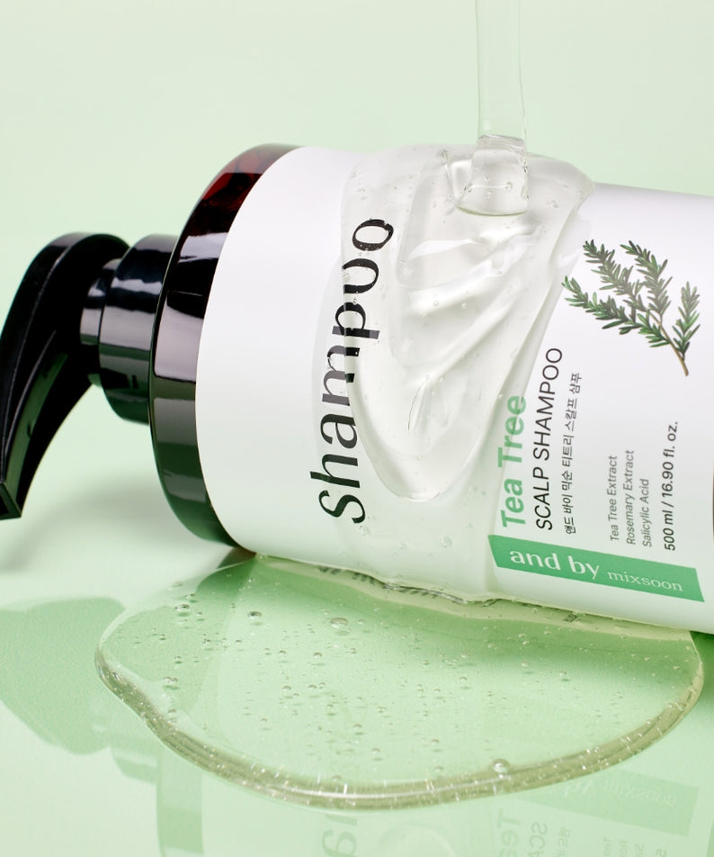 Bouteille de MIXSOON Tea Tree Scalp Shampoo 500ml avec du shampooing versé sur un fond vert clair, soin pour le cuir chevelu.