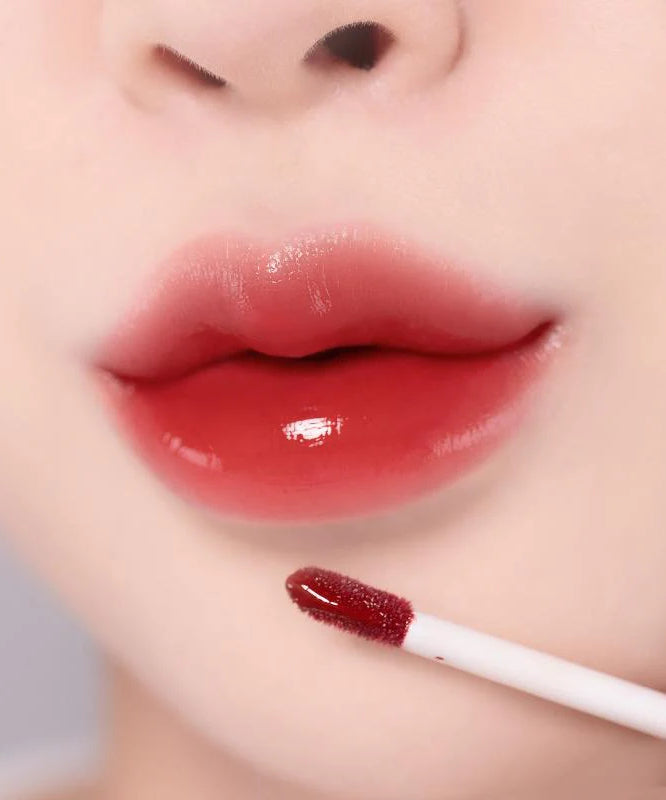 MOOLDA Glow Dewy Tint appliqué pour des lèvres brillantes et colorées en gros plan, montrant une finition éclatante.