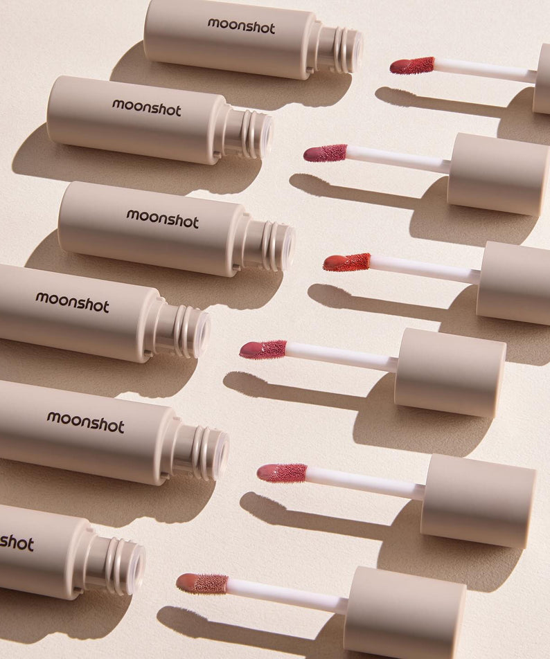 Gamme de teintes MOONSHOT Conscious Fit Melow Lip Tint sur fond beige. Rouge à lèvres liquide pour un look naturel et élégant.