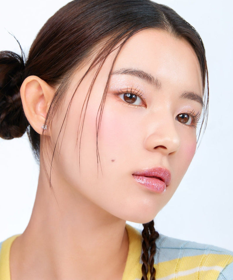 Femme portant MOONSHOT Melting Mood Lip & Cheek, maquillage délicat et éclat naturel. Cosmétiques multifonctions pour lèvres et joues.