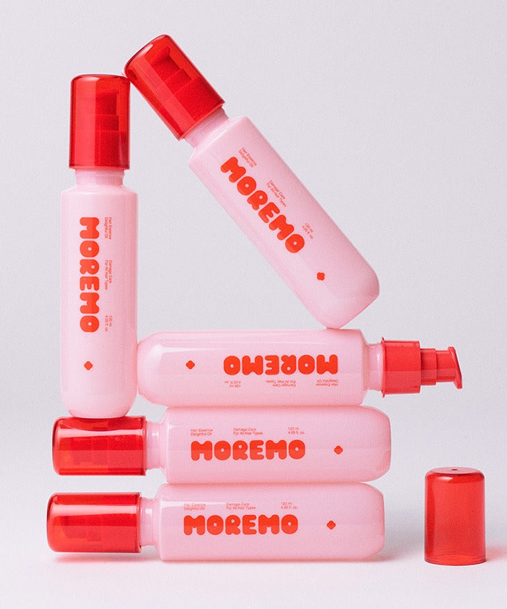 Image de MOREMO Hair Essence Delightful Oil 120ml, montrant plusieurs flacons roses alignés avec leurs bouchons rouges.